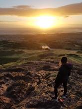 Isabel Martin standing on top of Arthur's Seat at sunrise