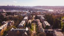 An ariel view of the University of Washington Quad during cherry blossom time looking out towards the downtown Seattle