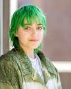 Professional headshot of Ari Forsyth, a white gender non-conforming person in their mid-20s with short green hair