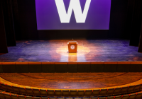 Meany Center stage with University of Washington's "W" block in white on the screen with a purple background