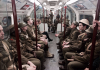 actors and artists performing world war soldiers riding London subway