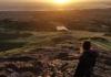 Isabel Martin standing on top of Arthur's Seat at sunrise